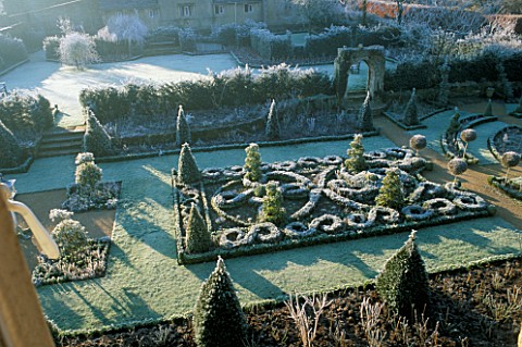 VIEW_ACROSS_THE_FROSTED_CELTIC_KNOT_GARDEN_WITH_LOLLIPOP_TOPIARY_AND_THE_SAXON_ARCH_THE_ABBEY_HOUSE_