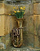 BRONZE TUBA FILLED WITH NARCISSUS TETE-A-TETE  MIDGET AND HAWERA. DESIGNED BY IVAN HICKS. GROOMBRIDGE PLACE  KENT.