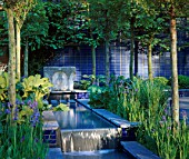 ROWS OF PLEACHED LIMES ALONG A WATER RILL WITH IRISES AND BLUE GLAZED BRICK WALLS. CARTIERS A CITY SPACE GARDEN DESIGNED BY MARK WALKER. CHELSEA 2000
