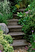 MAN MADE STEPS MADE TO LOOK LIKE WOODEN SLEEPERS  LINED WITH GRASSES & AJUGA. STONEMARKETS A WATERSIDE RETREAT DESIGNED BY GEOFFREY WHITEN. CHELSEA 2000