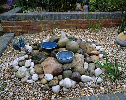 GRAVEL_BED_WITH_PEBBLE_WATER_FEATURE_AND_BLUE_CERAMIC_BOWLS_IN_ROBIN_GREEN_AND_RALPH_CADES_SEASIDE_S