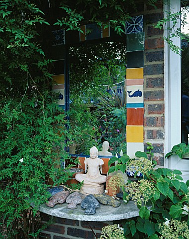 MIRROR_ON_HOUSE_WALL_SURROUNDED_BY_CERAMIC_TILES_ROBIN_GREEN_AND_RALPH_CADES_SEASIDE_STYLE_GARDEN__L
