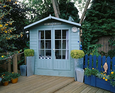 THE_UPPER_DECK_TERRACE_WITH_BLUE_SUMMERHOUSE__DECKING_AND_BLUE_DECORATIVE_FENCING_ROBIN_GREEN__RALPH