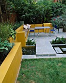 A PLACE TO SIT: ALUMINIUM TABLE AND CHAIRS ON PATIO SURROUNDED BY YELLOW RENDERED WALLS WITH RAISED BEDS AND RILL. OLEANDER IN GALVANISED CONTAINER. DESIGNER JOE SWIFT