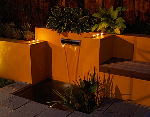 GARDEN_LIGHTING__WATER_FEATURE_POST_BOX_STYLE_FOUNTAIN_SURROUNDED_BY_YELLOW_RENDERED_WALLS_WITH_BENC