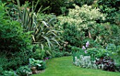 VIEW DOWN GARDEN WITH LAWN AND BORDERS WITH IRISES AND PHORMIUM. DESIGNER: SHEILA STEDMAN