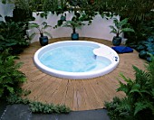 SPA POOL SURROUNDED BY PALMS IN POTS AND DECKING. HAMPTON COURT 2000  DESIGNER BOARDMAN GELLY & CO