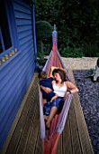 CLARE MATTHEWS RELAXES IN A HAMMOCK ON THE DECK TERRACE WITH HER SON  JOSHUA