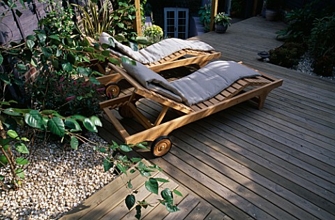 GARDEN_WITH_DECKING_DESIGNED_BY_JOE_SWIFT_AND_THAMASIN_MARSH_WOODEN_SUN_LOUNGERS_WITH_LILACGREY_FENC