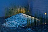 GLASS AND WATER GARDEN AT NIGHT. LIGHTING SHAFTS ACROSS CRUSHED GLASS MOUNDS INTERPLANTED WITH  TYPHA. DESIGNED BY S.L.U ALNARP. HEDENS LUSTGARD  SWEDEN