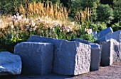 ANGULAR ROCKS SURROUND MINIMALIST GARDEN BY ULF NORDFJELL. PLANTING WITH LILUM REGALE AND DESCHAMPSIA CESPITOSA.  HEDENS LUSTGARD  SWEDEN