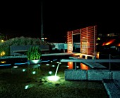 NIGHT TIME VIEW ACROSS MINIMALIST WATER GARDEN  DESIGNED BY ULF NORDFJELL.  DECKING  SCREEN AND WATER FEATURE.  HEDENS LUSTGARD  SWEDEN