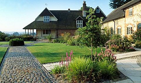 THE_HOUSE_WITH_BOX_TOPIARY_AND_PATHS_MADE_FROM_GRANITE_SETTS_BURY_COURT__HAMPSHIRE