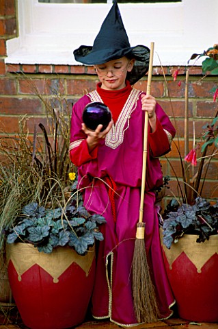 ROBERT_DRESSED_AS_A_WIZARD_HOLDS_A_PURPLE_BAUBLE_AND_STANDS_IN_FRONT_OF_POTS_OF_HEUCHERA_QUICKSILVER