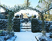 EASTLEACH HOUSE  GLOUCS  COVERED IN SNOW  VIEWED FROM THE WALLED GARDEN