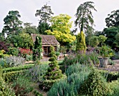 THE SUMMERHOUSE WITH ROBINIA PSEUDOACACIA FRISIA  LARCH SCOTS PINE  LAVENDER  BOX SPIRALS  FASTIGIATE GOLDEN YEW AND CHAMAEOPS HUMILIS. EASTLEACH HOUSE  GLOUCS