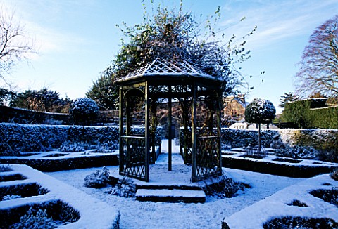 EASTLEACH_HOUSE_GARDEN__GLOUCESTERSHIRE_THE_BANDSTAND_IN_THE_WALLED_GARDEN_COVERED_WITH_SNOW