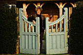 LADY FARM  SOMERSET  IN WINTER: JUDY PEARCE LEANS AGAINST A BLUE GATE ON THE UPPER LAWN