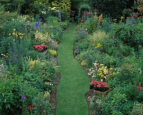 RED_GABLES__WORCESTERSHIRE_HERBACEOUS_BORDERS_AND_GRASS_WALK_WITH_URNS_PLANTED_WITH_PELARGONIUM_RED_