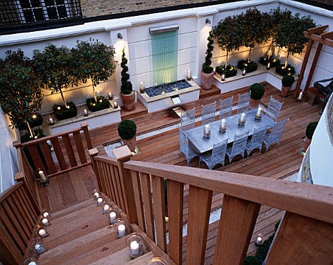 MODERN_ROOF_GARDEN_WITH_DECKING__GLASS_WATERB_FEATURE__CLIPPED_BOX__STANDARD_PHOTINIAS__SILVER_TABLE