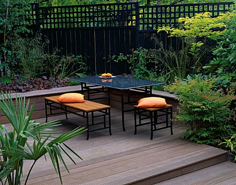 BELAU_DECK_TERRACE_WITH_BLACK_MARBLE_TABLE_AND_CHAIRS__ORANGE_CUSHIONS__BLACK_FENCE_AND_TRELLIS__ROB