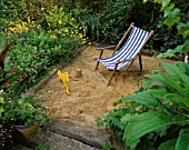 SANDPIT WITH RAILWAY SLEEPER EDGES AND DECKCHAIR. DAVID AND MARIE CHASES GARDEN  HAMPSHIRE