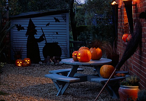 HALLOWEEN_GRAVEL_COURTYARD_WITH_BLUE_TABLE__PUMPKINS__BESOM_BROOM__BLUE_SHED_WITH_WITCH_AND_COULDRON