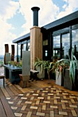 AFRICAN THEMED ROOF TERRACE: IROKO DECKING WITH INSET HERRINGBONE DESIGN PANELS IN COLOURED WOOD. ZINC-WRAPPED TABLE  STAINLESS STEEL THRONE CHAIRS.  DESIGN: S. WOODHAMS