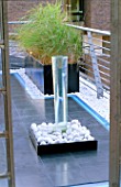 ROOF GARDEN DETAIL: WATER FEATURE WITH WHITE COBBLES  NEON STRIP LIGHTING  AND BLACK SLATE. GARDEN DESIGNED BY STEPHEN WOODHAMS