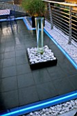 ROOF GARDEN DETAIL: WATER FEATURE WITH WHITE COBBLES  NEON STRIP LIGHTING  AND BLACK SLATE. GARDEN DESIGNED BY STEPHEN WOODHAMS