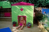 CHILDRENS DECK GARDEN: LUCY PLAYS OUTSIDE THE FOLDAWAY WENDY HOUSE ON THE DECK WITH