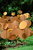 DISCS OF COPPER COLOURED NYLON BALLOON FABRIC BY PAUL LANGH IN THE HARBOUR UNDER SAIL GARDEN AT THE WESTONBIRT FESTIVAL OF GARDENS 2002