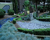 HELTER SKELTER   GARDEN CREATED BY TONY HEYWOOD OF CONCEPTUAL GARDENS  LONDON: BOX HEDGING  FESTUCA GLAUCA  ROCKS  SLATE  A CURVED MIRROR OF MARINE STEEL & TWISTED LEAD