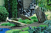 HELTER SKELTER   GARDEN CREATED BY TONY HEYWOOD OF CONCEPTUAL GARDENS  LONDON: ROCKS  GRASSES  TWISTED LEAD AND YEW TOPIARY