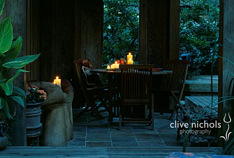 INSIDE_OF_THE_INDONESIAN_GAZEBO_WITH_WOODEN_HAND_CHAIRS__TABLE_AND_CHAIRS__AND_CANDLES_DESIGNERS_ILG