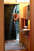 BOB SWAIN USING THE OUTDOOR SHOWER INSIDE: DESIGNED BY BOB SWAIN  SEATTLE  USA
