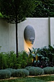 SANCTUARY GARDEN SPONSORED BY MERRILL LYNCH AT THE CHELSEA FLOWER SHOW 2002: DESIGNED BY STEPHEN WOODHAMS: ONE OF THE FIVE FACE SCULPTURES BY STEPHEN COX WITH LIGHTING