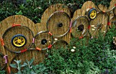 CHELSEA FLOWER SHOW 2003. DESIGNER: POZ MARTIN AND DEENA KESTENBAUM: FENCE MADE FROM RE-CYCLED BICYCLE WHEELS