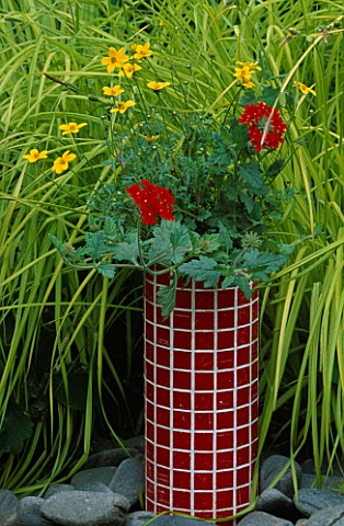 DESIGNER_CLARE_MATTHEWS_RED_MOSAIC_TUBE_CONTAINER_PLANTED_WITH_BIDENS_YELLOW_BREEZE_AND_VERBENA_SUNM