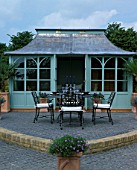 HOUSE BEAUTIFUL GARDEN  HAMPTON COURT 2003: DESIGNER DAVID DOMONEY. SUMMERHOUSE WITH ARCH SHAPED PATIO AND TABLE AND CHAIRS