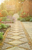 VIEW ALONG GRAVEL AND BRICK PATH. DESIGNER: ANGEL COLLINS