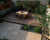 ROOF GARDEN: LIMESTONE PAVING  BEECH PEBBLES  TEAK TABLE AND CHAIRS  ITALIAN POLISHED PLASTER WALL  AND BETULA JACQUEMONTII. DESIGNER: CHARLOTTE SANDERSON