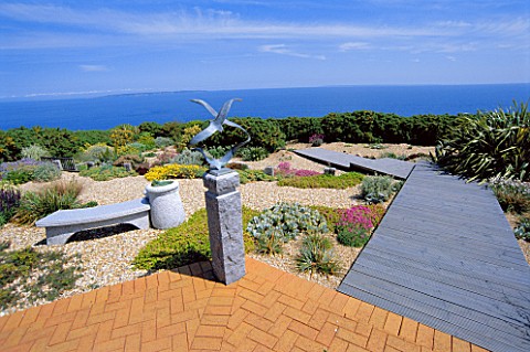 SEASIDE_GARDEN__GUERNSEY_VIEW_OUT_TO_SEA_WITH_BRICK_PATIO__GRAVEL__WOODEN_BOARDWALK__CHINESE_GRANITE