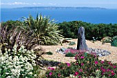 SEASIDE GARDEN  GUERNSEY: VIEW OUT TO SEA AND THE ISLAND OF SARK WITH GRAVEL GARDEN  SLATE WATER FEATURE  CENTRANTHUS ALBA  THRIFT AND PHORMIUMS