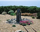 SEASIDE GARDEN  GUERNSEY: VIEW OUT TO SEA AND THE ISLAND OF SARK WITH GRAVEL GARDEN  SLATE WATER FEATURE  PEBBLES AND THRIFT