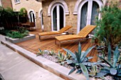 WOOD AND LIMESTONE TERRACE BESIDE HOUSE WITH SUN LOUNGERS  TAMARIX  AGAVE AMERICANA AND AGAVE AMERICANA VARIEGATA.  DESIGN : AMIR SCHLEZINGER/ MY LANDSCAPES