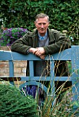PAUL PICTON LEANS ON THE GATE AT THE PICTON GARDEN  WORCESTERSHIRE