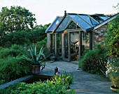 VIEW OF DECK WITH POOL  AGAVE AMERICANA IN CONTAINER AND GARDEN ROOM BEHIND. THE FOVANT HUT  WILTSHIRE