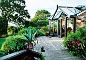VIEW OF DECK WITH POOL  AGAVE AMERICANA IN CONTAINER AND GARDEN ROOM BEHIND. THE FOVANT HUT  WILTSHIRE