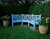 KELMARSH HALL  NORTHAMPTONSHIRE: BLUE SEAT SURROUNDED BY TERRACOTTA CONTAINERS PLANTED WITH NARCISSI